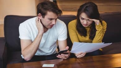 couple sitting sofa discussing with financial documents living room 107420 84892