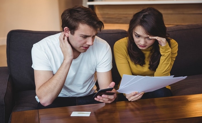 couple sitting sofa discussing with financial documents living room 107420 84892