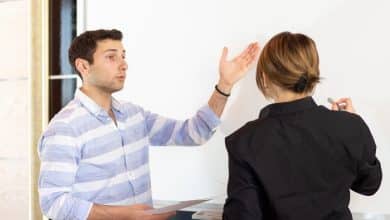 front view young attractive businesswoman black shirt along with young man discussing graphics desk while young lady presents her work reading document job building presentation 140725 16125