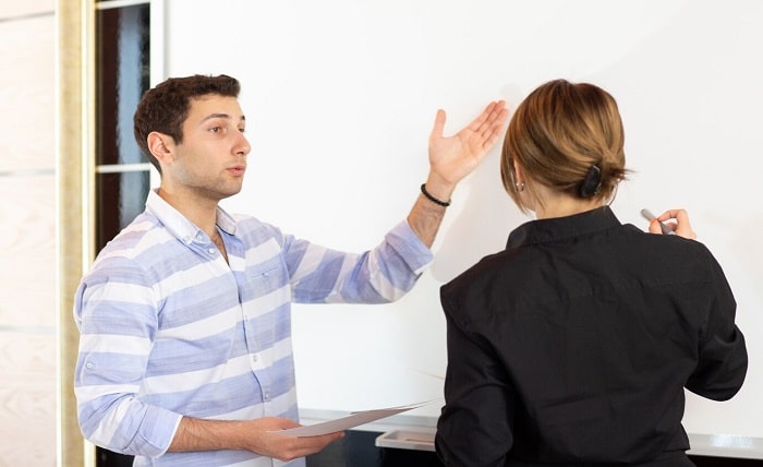 front view young attractive businesswoman black shirt along with young man discussing graphics desk while young lady presents her work reading document job building presentation 140725 16125