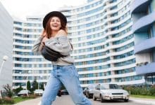 outdoor image joyful girl black wool hat grey fall sweater jumping enjoying walk modern urban city 273443 1874