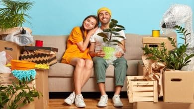 smiling young couple sitting couch surrounded by boxes 273609 31637