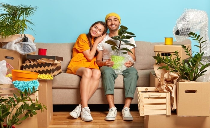 smiling young couple sitting couch surrounded by boxes 273609 31637