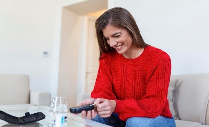 woman using lancelet finger woman doing blood sugar test home living room 657921 455