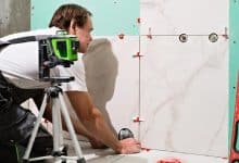 professional master man laying ceramic tiles wall bathroom portrait experienced repairman laying large size porcelain tilesconstruction worker checking tile installation with laser level 166373 2067