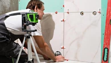 professional master man laying ceramic tiles wall bathroom portrait experienced repairman laying large size porcelain tilesconstruction worker checking tile installation with laser level 166373 2067