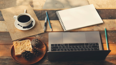 A cozy home office setup with a laptop, coffee, notebook, and toast on a wooden table, representing productive remote work routines